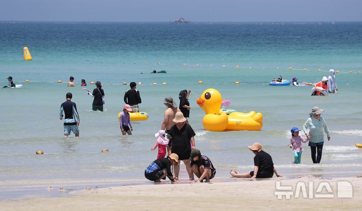 [제주=뉴시스] 우장호 기자 = 무더위가 기승을 부린 3일 오후 제주시 한림읍 협재해수욕장을 찾은 피서객들이 바닷물에 발을 담그며 더위를 식히고 있다. 기상청은 이날 제주 지역 장마가 사실상 지난달 26일 종료됐다고 발표했다. 올해 제주 장마 기간은 지난달 12~26일로 2주간이었으며, 이는 기상 관측 사상 가장 일찍 종료된 장마로 기록됐다. 2025.07.03. woo1223@newsis.com
