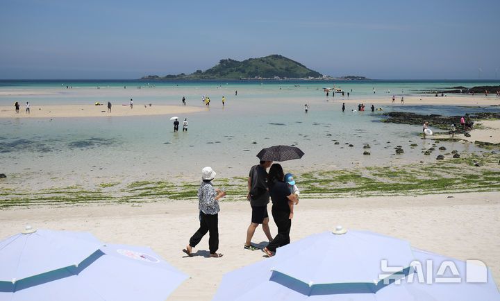 [제주=뉴시스] 우장호 기자 = 무더위가 기승을 부린 3일 오후 제주시 한림읍 협재해수욕장을 찾은 피서객들이 바닷물에 발을 담그며 더위를 식히고 있다. 기상청은 이날 제주 지역 장마가 사실상 지난달 26일 종료됐다고 발표했다. 올해 제주 장마 기간은 지난달 12~26일로 2주간이었으며, 이는 기상 관측 사상 가장 일찍 종료된 장마로 기록됐다. 2025.07.03. woo1223@newsis.com