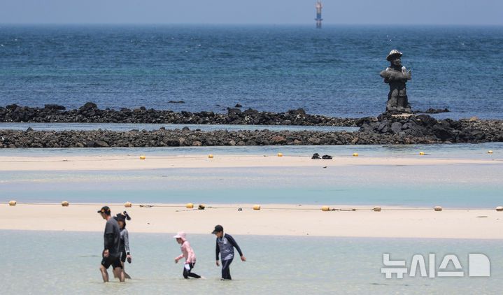 [제주=뉴시스] 우장호 기자 = 무더위가 기승을 부린 3일 오후 제주시 한림읍 금능해수욕장을 찾은 피서객들이 바닷물에 발을 담그며 더위를 식히고 있다. 기상청은 이날 제주 지역 장마가 사실상 지난달 26일 종료됐다고 발표했다. 올해 제주 장마 기간은 지난달 12~26일로 2주간이었으며, 이는 기상 관측 사상 가장 일찍 종료된 장마로 기록됐다. 2025.07.03. woo1223@newsis.com