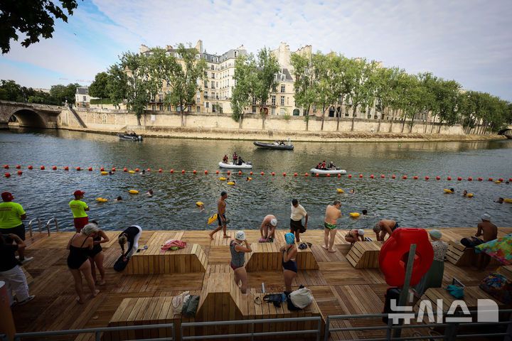 [파리=AP/뉴시스] 5일(현지 시간) 프랑스 파리 센 강에서 시민들이 수영을 하고 있다. 센 강은 100여 년 만에 공공 수영 공간으로 개방됐다. 마리 수로, 베르시 강변, 그르넬 항구 근처 등 세 곳이 야외 수영 구역으로 지정됐으며 오는 8월 31일까지 무료로 개방된다. 탈의실, 샤워 시설, 파라솔, 비치체어 등이 갖춰졌다. 2025.07.07.
