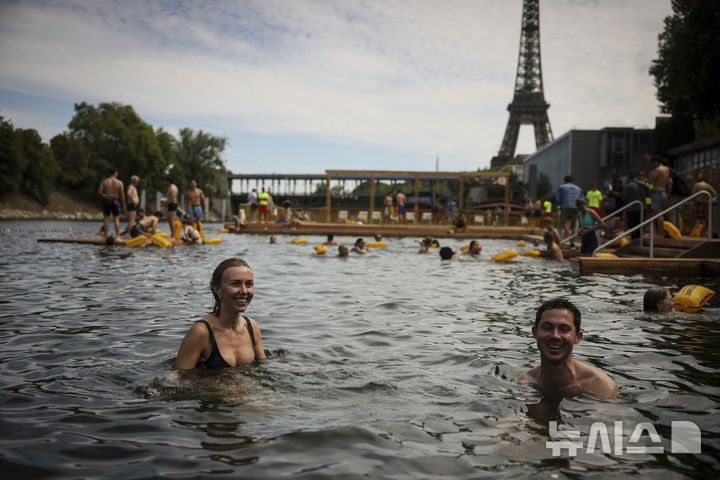 [파리=AP/뉴시스] 5일(현지 시간) 프랑스 파리 센 강에서 시민들이 수영을 하고 있다. 센 강은 100여 년 만에 공공 수영 공간으로 개방됐다. 마리 수로, 베르시 강변, 그르넬 항구 근처 등 세 곳이 야외 수영 구역으로 지정됐으며 오는 8월 31일까지 무료로 개방된다. 탈의실, 샤워 시설, 파라솔, 비치체어 등이 갖춰졌다. 2025.07.07.