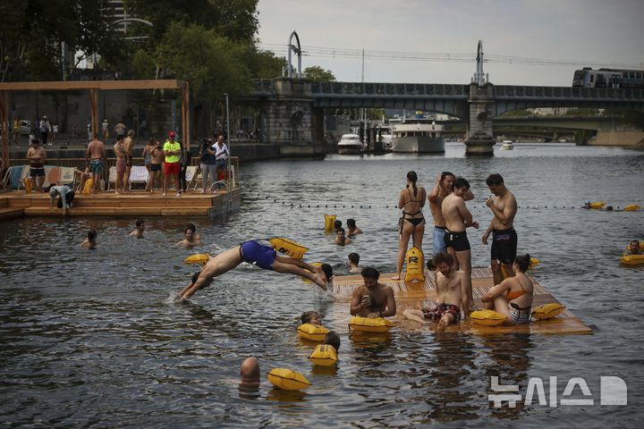 [파리=AP/뉴시스] 5일(현지 시간) 프랑스 파리 센 강에서 시민들이 수영을 하고 있다. 센 강은 100여 년 만에 공공 수영 공간으로 개방됐다. 마리 수로, 베르시 강변, 그르넬 항구 근처 등 세 곳이 야외 수영 구역으로 지정됐으며 오는 8월 31일까지 무료로 개방된다. 탈의실, 샤워 시설, 파라솔, 비치체어 등이 갖춰졌다. 2025.07.07.