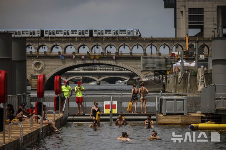 [파리=AP/뉴시스] 5일(현지 시간) 프랑스 파리 센 강 베르시에서 시민들이 수영을 하고 있다. 센 강은 100여 년 만에 공공 수영 공간으로 개방됐다. 마리 수로, 베르시 강변, 그르넬 항구 근처 등 세 곳이 야외 수영 구역으로 지정됐으며 오는 8월 31일까지 무료로 개방된다. 탈의실, 샤워 시설, 파라솔, 비치체어 등이 갖춰졌다. 2025.07.07.