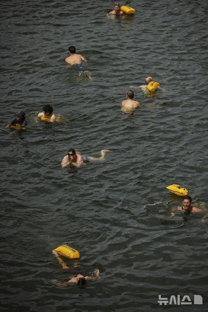 [파리=AP/뉴시스] 5일(현지 시간) 프랑스 파리 센 강에서 시민들이 수영을 하고 있다. 센 강은 100여 년 만에 공공 수영 공간으로 개방됐다. 마리 수로, 베르시 강변, 그르넬 항구 근처 등 세 곳이 야외 수영 구역으로 지정됐으며 오는 8월 31일까지 무료로 개방된다. 탈의실, 샤워 시설, 파라솔, 비치체어 등이 갖춰졌다. 2025.07.07.