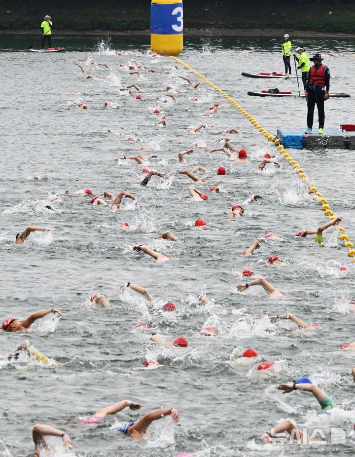 [서울=뉴시스] 김근수 기자 = 6일 오전 서울 송파구 롯데월드타워 일대에서 열린 '2025 롯데 아쿠아슬론'에서 참가자들이 수영을 하고 있다. 철인 3종 경기에서 사이클론을 제외한 오픈워터 수영과 마라톤을 함께 겨루는 '2024 롯데 아쿠아슬론'은 석촌호수 두 바퀴(총 1.5Km)를 완영 후, 롯데월드타워 1층부터 123층까지 2,917개의 계단을 오르는 수직 마라톤 스카이런(SKY RUN)으로 진행됐다.(공동취재) 2025.07.06. photo@newsis.com