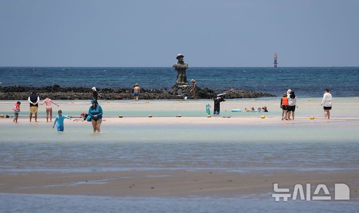 [제주=뉴시스] 우장호 기자 = 폭염의 기세가 수그러들지 않는 6일 오후 제주시 한림읍 금능해수욕장을 찾은 피서객들이 시원한 바닷물에 발을 담그며 더위를 식히고 있다. 2025.07.06. woo1223@newsis.com