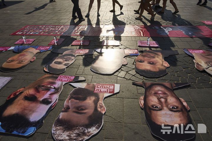 [텔아비브=AP/뉴시스] 7일 이스라엘 텔아비브에 있는 미국 대사관 분관 앞에서 가자 종전과 인질 석방을 요구하는 시위대가 하마스에 억류된 인질들의 사진을 놓아두고 있다.  2025.07. 14.