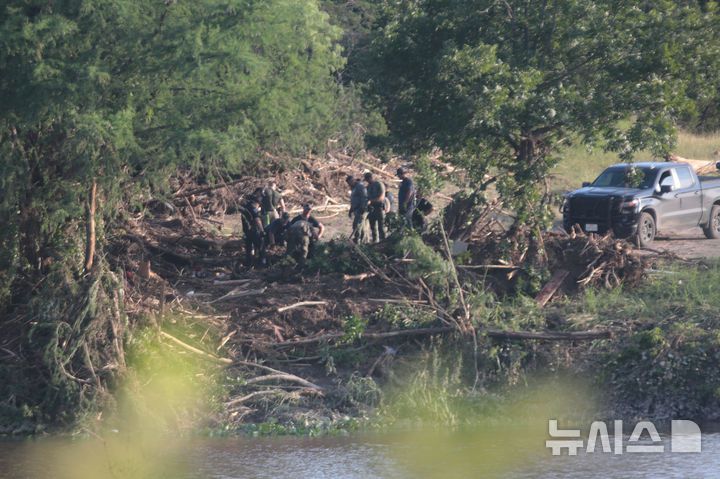 [커빌=AP/뉴시스] 7일(현지 시간) 미 텍사스주 커빌에서 경찰이 과달루페강 주변을 수색하고 있다. 텍사스주를 강타한 폭우와 홍수로 '캠프 미스틱'에 참가했던 어린이 중 27명이 숨지면서 사망자 수는 100명을 넘어선 것으로 알려졌다. 2025.07.08.
