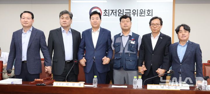 [세종=뉴시스] 강종민 기자 = 최저임금위원회 이인재 위원장과 권순원 공익위원, 류기정 사용자 위원, 류기섭 근로자 위원 등이 지난 10일 밤 세종시 정부세종청사에서 2026년도 적용 최저임금안을 합의로 결정한 뒤 손을 맞잡고 있다. 내년도 최저임금은 1만 320원으로 결정됐다. 2024.07.11. ppkjm@newsis.com