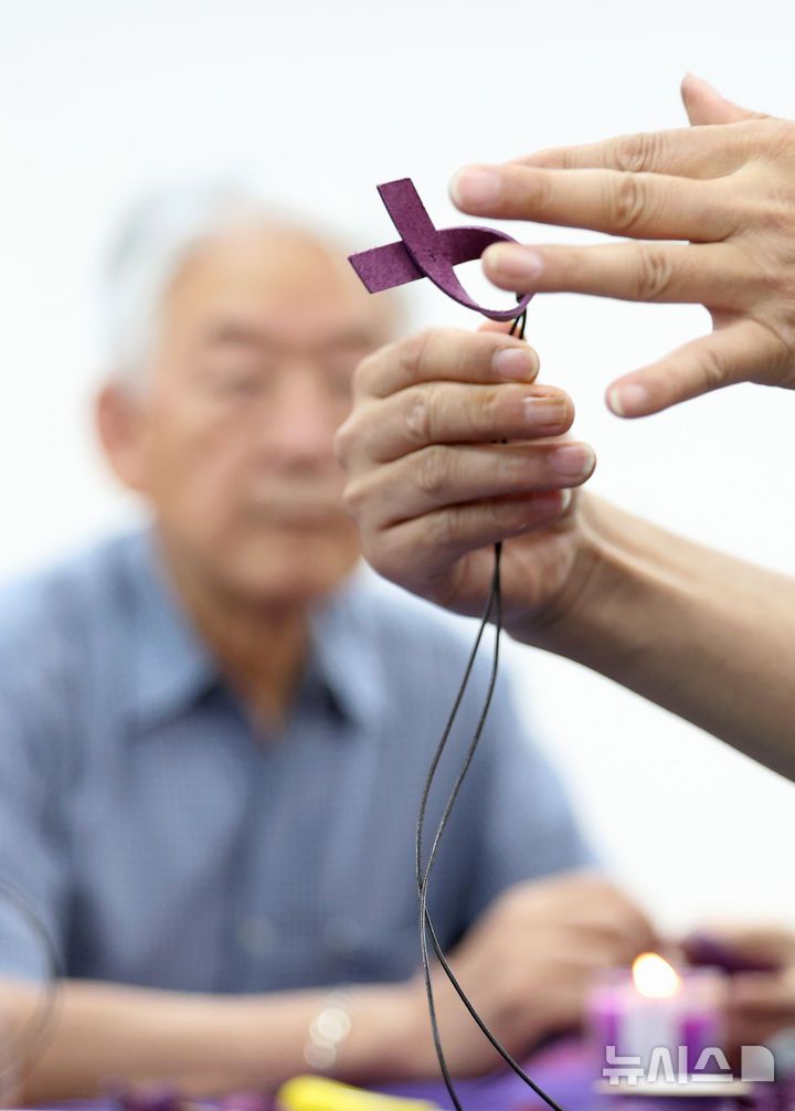 [서울=뉴시스] 김진아 기자 = 10·29 이태원참사 유가족협의회·시민대책회의를 비롯한 참석자들이 12일 서울 종로구 별들의집에서 열린 10.29 이태원 참사, 함께 만드는 1000일 '1000개의 별목걸이 함께 만들어요'에서 보라리본 목걸이를 만들고 있다. 2025.07.12. bluesoda@newsis.com