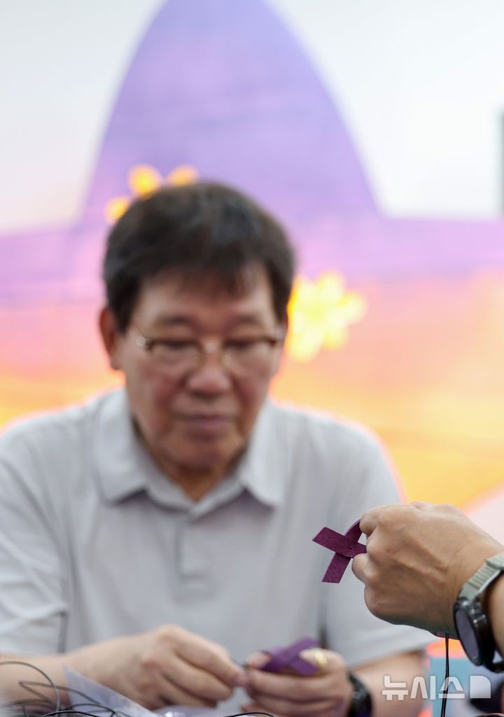 [서울=뉴시스] 김진아 기자 = 10·29 이태원참사 유가족협의회·시민대책회의를 비롯한 참석자들이 12일 서울 종로구 별들의집에서 열린 10.29 이태원 참사, 함께 만드는 1000일 '1000개의 별목걸이 함께 만들어요'에서 보라리본 목걸이를 만들고 있다. 2025.07.12. bluesoda@newsis.com