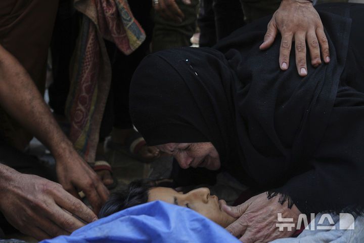 [누세이라트=AP/뉴시스] 13일(현지 시간) 가자지구 중부 누세이라트 알 아우다 병원에서 식수 배급 중 이스스라엘 군 공습으로 사망한 어린이의 가족들이 슬픔에 잠겨 있다. 2025.07.14.