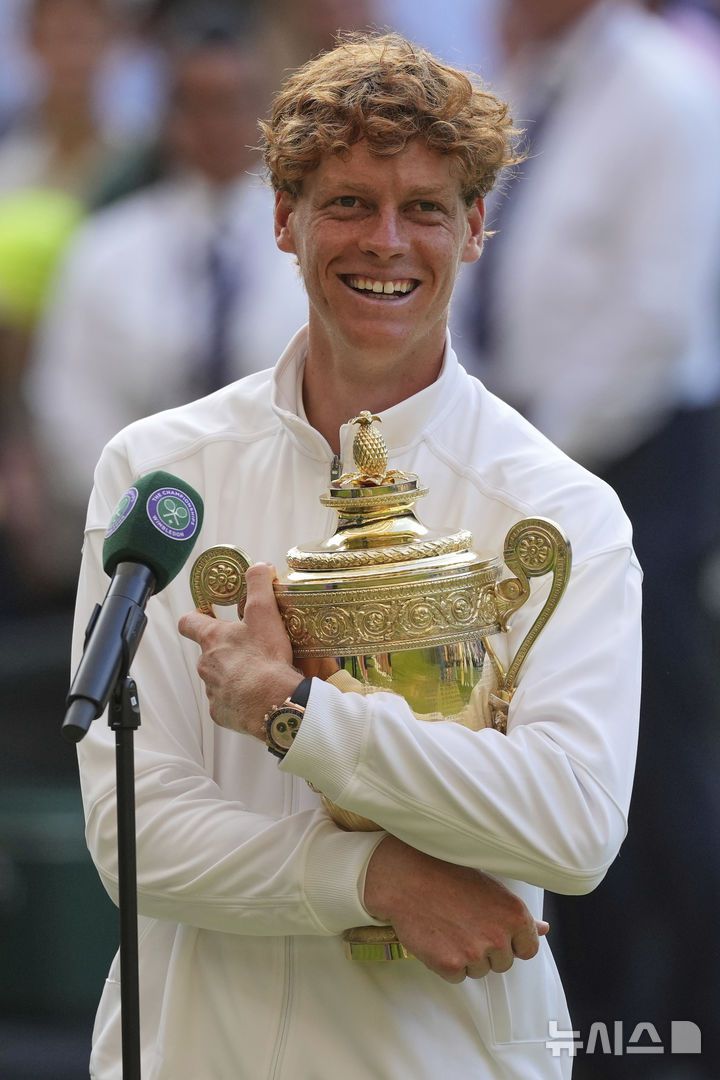 [런던=AP/뉴시스] 얀니크 신네르(1위·이탈리아)가 13일(현지 시간) 영국 런던 올잉글랜드 클럽에서 열린 2025 윔블던 테니스 대회 남자 단식 정상에 올라 트로피를 품에 안고 활짝 웃고 있다. 신네르는 결승에서 3연패를 노리는 카를로스 알카라스(2위·스페인)에게 3-1(4-6 6-4 6-4 6-4) 역전승을 거두고 윔블던 첫 우승을 차지했다. 2025.07.14.