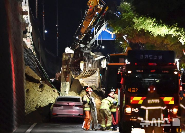 [오산=뉴시스] 김종택 기자 = 수도권 등 중부지역에 호우주의보가 발효된 16일 오후 경기 오산시 가장교차로 고가도로 옹벽이 무너져 소방관들이 매몰된 차량을 구조작업하고 있다. 2025.07.16. jtk@newsis.com