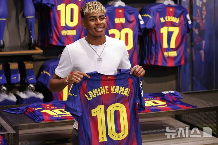 [바르셀로나=AP/뉴시스] FC 바르셀로나의 라민 야말이 16일(현지 시간) 스페인 바르셀로나에서 구단과 재계약을 체결한 후 본인의 이름이 적힌, 등 번호 10번의 새 유니폼을 들고 포즈를 취하고 있다. 야말은 2031년까지 재계약을 체결하고 구단의 상징적 등 번호인 '10번'의 새 주인이 됐다. 2025.07.17.