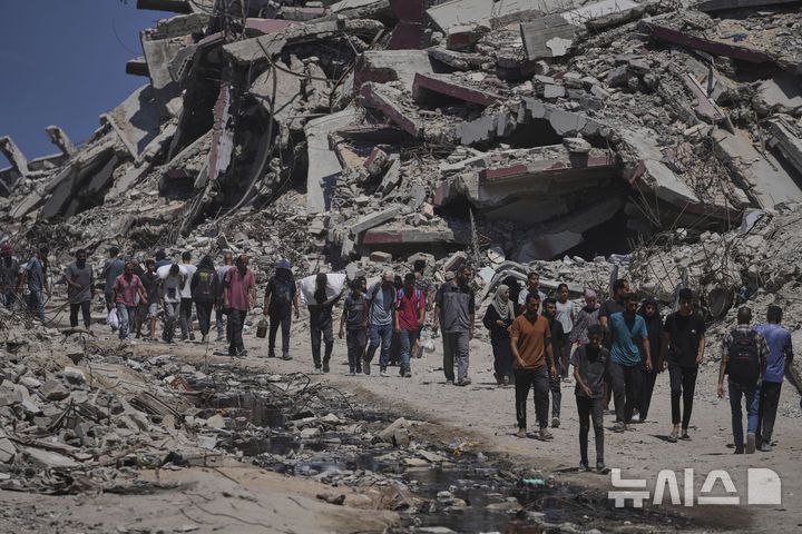 [가자지구=AP/뉴시스] 20일(현지 시간) 팔레스타인 주민들이 가자지구 북부에서 구호품을 나르고 있다. 2025.07.21.