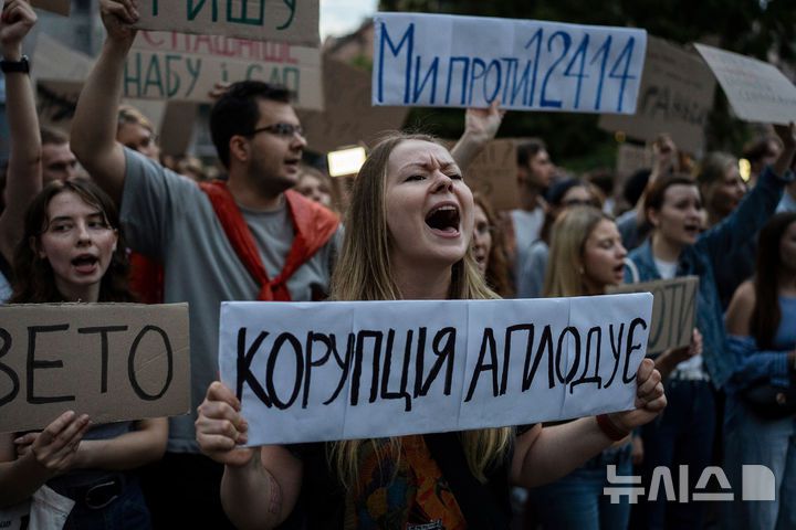 [키이우=AP/뉴시스] 22일(현지 시간) 볼로디미르 젤렌스키 대통령 정부의 반부패기관 무력화 조치에 항의하는 대규모 시위가 벌어진 가운데, 우크라이나 수도 키이우 마이단 광장에서 한 시위대가 "부패 조장"이라고 적힌 손팻말을 들고 있다. 2025.7.23.