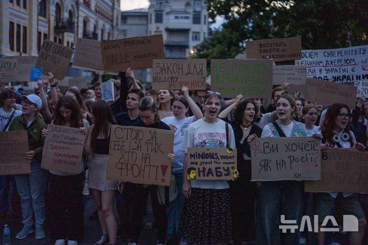 [키이우=AP/뉴시스] 22일(현지 시간) 우크라이나 키이우에서 반부패 기관의 독립성을 박탈하는 정부의 법안 통과에 항의하는 시위에 참여한 사람들이 "러시아처럼 될 것인가" "우리의 미래를 훔치지 말라" 등의 내용이 적힌 손팻말을 들고, 구호를 외치고 있다. 2025.07.23.