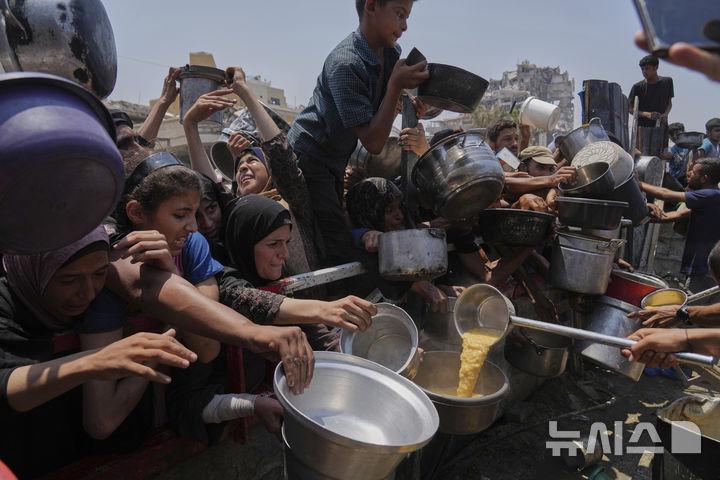 [가자시티=AP/뉴시스] 기아 위기가 고조되는 가자지구 가자시티에서 26일(현지 시간) 주민들이 힘겹게 식량을 받고 있다. 2025.07.26.