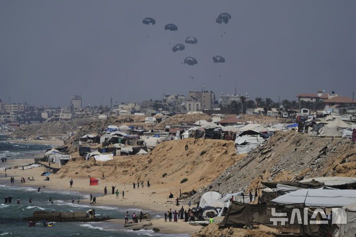 [가자시티=AP/뉴시스] 28일(현지 시간) 가자지구 중부 상공에서 팔레스타인 주민들에게 나눠줄 인도적 지원 물품이 공중 투하되는 모습이 칸유니스에서 관측되고 있다. 2025.07.29.