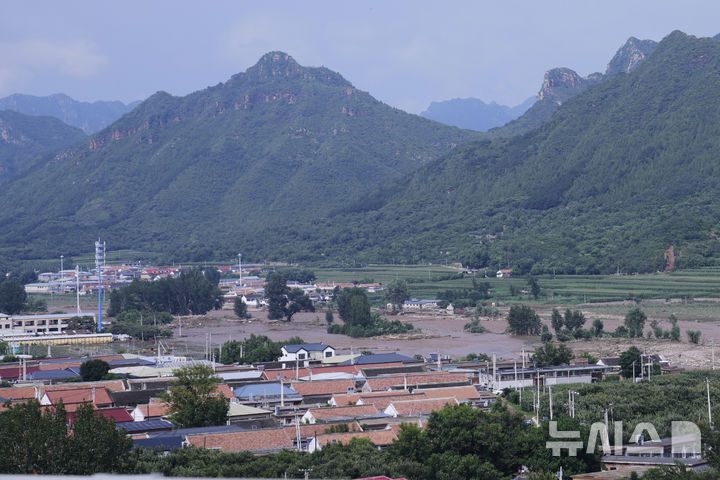 [베이징=AP/뉴시스] 중국 수도권 지역에 쏟아진 기록적 폭우로 베이징에서만 30명이 숨지고, 8만 명이 넘는 주민이 긴급 대피했다. 사진은 28일 중국 베이징 미윈구에서 마을이 홍수에 잠긴 모습. 2025.07.29