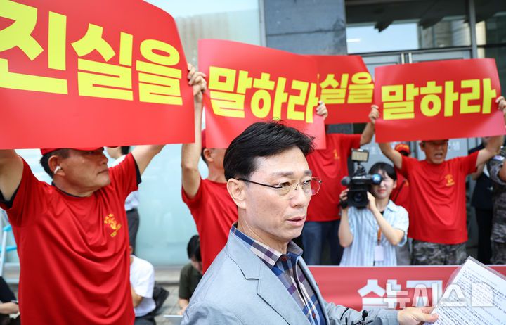 [서울=뉴시스] 최진석 기자 = 해병대 예비역 연대 회원들이 29일 오전 서울 서초구 이명현 순직 해병 특별검사 사무실 앞에서 '신속한 결정 요청서' 제출에 앞서 발언하는 임성근 전 해병대 1사단장 뒤에서 피켓을 들고 있다. 2025.07.29. myjs@newsis.com