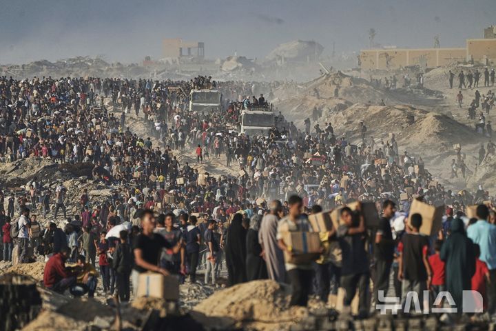 [AP/뉴시스] 6월16일 사진으로 가자 지구 북부의 가자 시티에 유엔의 세계식량프로그램이 구호물자 트럭을 끌고오자 굶주린 사람들이 떼로 몰려들었다. 가자 중남부에서 미국 민간조직 '가자 인도주의재단(GHF)'이 독점적으로 식량을 배급한 지 20일 뒤 모습이다.