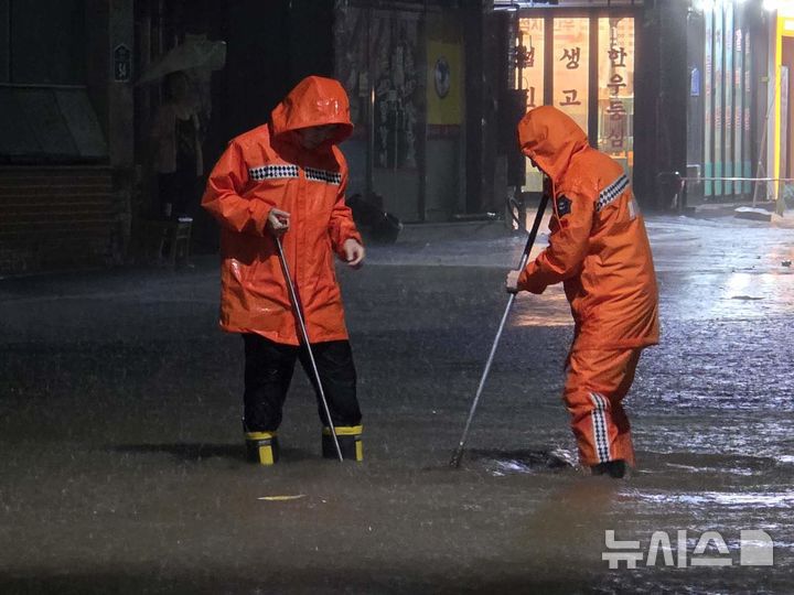 [광주=뉴시스] 광주지역에 폭우가 쏟아진 지난 3일 오후 광주 북구 운암동에서 주민들이 침수 피해를 막기 위해 주변 쓰레기를 정리하고 있다. (사진 = 독자 제공) 2025.08.03. photo@newsis.com