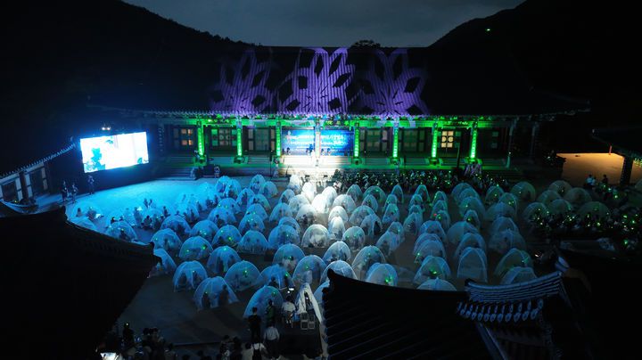 [서울=뉴시스] 고범준 기자 = 지난 2일 지리산 대화엄사 화엄원 특설무대에서 열린 제5회 지리산 대화엄사 모기장영화음악회에서 관객들이 공연을 보고 있다. (사진=지리산 대화엄사 제공) 2025.08.03. photo@newsis.com *재판매 및 DB 금지