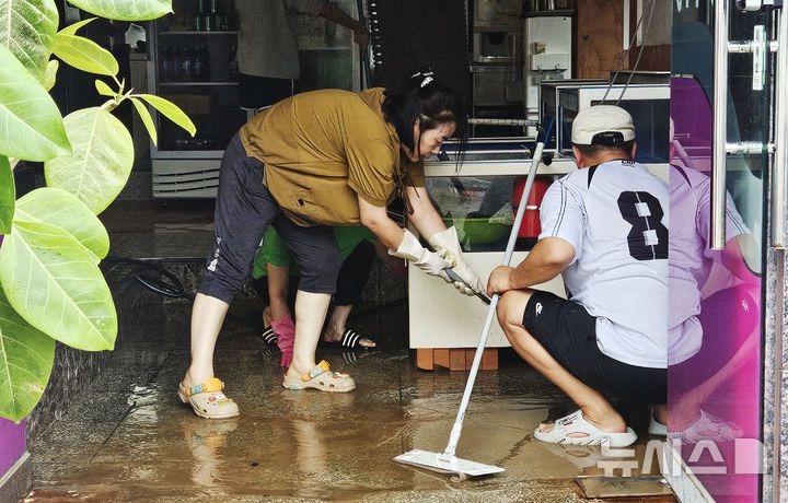 [무안=뉴시스]박상수 기자 = 4일 오전 전남 무안군 무안읍에서 상가 주인이 전날 내린 폭우로 잠긴 상가를 정리하고 있다. parkss@newsis.com 2025.08.03.