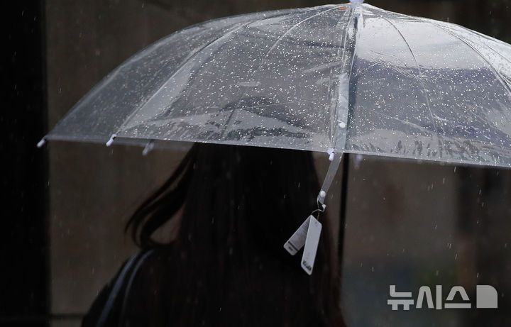 [제주=뉴시스] 우장호 기자 = 정체전선 영향으로 호우특보가 내려진 11일 오전 제주시 노형오거리 인근 거리에서 갑작스러운 비에 우산을 구입한 시민이 상표도 떼지 못하고 걸음을 재촉하고 있다. 2025.08.11. woo1223@newsis.com