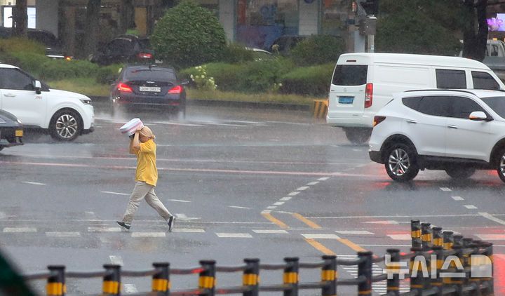 [제주=뉴시스] 우장호 기자 = 정체전선 영향으로 호우특보가 내려진 11일 오전 제주시 노형오거리 인근 횡단보도에서 우산을 준비하지 못 한 시민이 비를 피해 뛰어가고 있다. 2025.08.11. woo1223@newsis.com