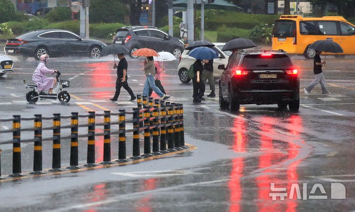 [제주=뉴시스] 우장호 기자 = 정체전선 영향으로 호우특보가 내려진 11일 오전 제주시 노형오거리 인근 거리에 우산을 쓴 시민들이 걸어가고 있다. 2025.08.11. woo1223@newsis.com