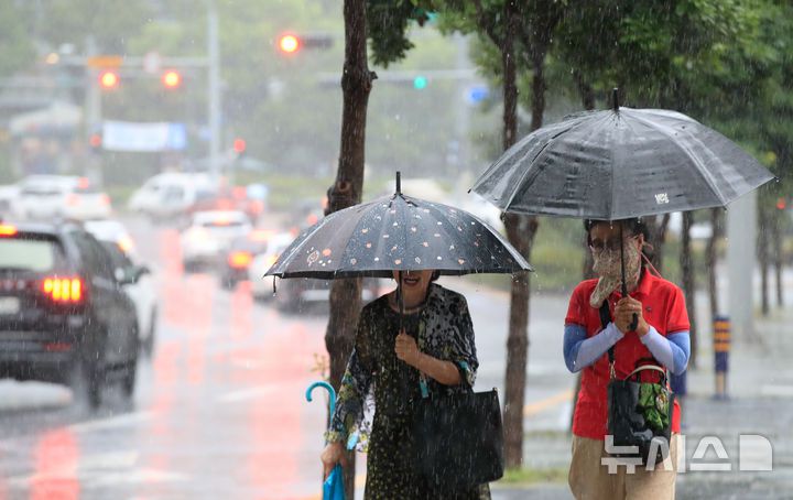 [제주=뉴시스] 우장호 기자 = 정체전선 영향으로 호우특보가 내려진 11일 오전 제주시 노형오거리 인근 거리에 우산을 쓴 시민들이 걸어가고 있다. 2025.08.11. woo1223@newsis.com