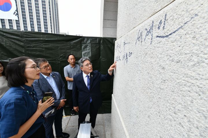 [서울=뉴시스] 허민 국가유산청장이 11일 낙서로 훼손된 서울 종로구 경복궁 광화문 석축을 찾아 피해 규모를 관계자들과 점검하고, 긴급 복구 방안을 논의하고 있다. (사진=국가유산청 제공) 2025.08.11. photo@newsis.com *재판매 및 DB 금지