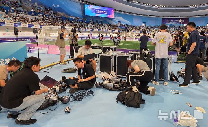 [베이징=뉴시스] 박정규 특파원 = 15일 오전 '2025 세계휴머노이드로봇운동회'가 열린 중국 베이징 국가스피드스케이팅경기장에서 로봇축구 경기가 펼쳐지는 가운데 참가자들이 로봇을 점검하고 있다. 이번 대회가 열리는 15일부터 17일까지 16개국에서 참가한 280개 팀이 달리기·축구·격투기 등 각종 스포츠 종목을 비롯해 군무·무술이나 약품·물건 옮기기 등 다양한 종목에서 경쟁을 펼친다. 2025.08.15 pjk76@newsis.com