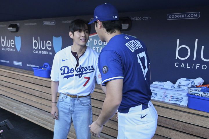 [로스앤젤레스=AP/뉴시스] 방탄소년단(BTS)의 뷔(왼쪽)가 25일(현지 시간) 미 캘리포니아주 로스앤젤레스의 다저 스타디움에서 LA 다저스 오타니 쇼헤이와 인사를 나누고 있다. 뷔는 이날 LA 다저스와 신시내티 레즈의 경기에 앞서 시구한다. 2025.08.26.