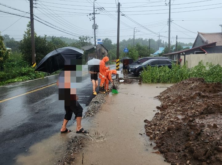 [군산=뉴시스] 26일 전북 군산시 회현면의 한 도로에서 호우로 인해 하수구가 막혀 물이 고이자 소방대원들이 조치에 나서고 있다. (사진=전북도소방본부 제공) 2025.08.26. photo@newsis.com *재판매 및 DB 금지
