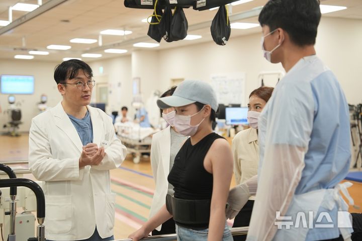 [서울=뉴시스] 신홍경 분당서울대병원 응급외상중환자외과 교수가 엥흐진 환자의 재활 치료에 대해 상의하는 모습. (사진= 분당서울대병원 제공)