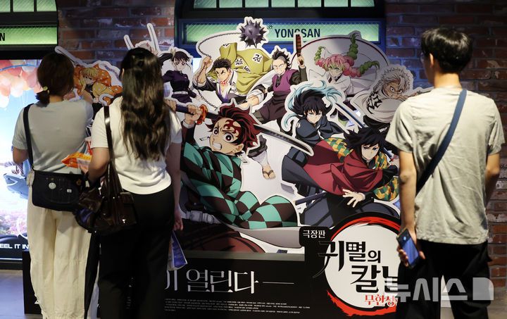 [서울=뉴시스] 조성우 기자 = 일본 애니메이션 영화 '극장판 귀멸의 칼날:무한성편'이 개봉 10일 만에 300만 관객을 넘긴 가운데 31일 서울 시내의 한 영화관에 시민들이 '귀멸의 칼날' 홍보물을 살펴보고 있다. 영화관입장권 통합전산망과 배급사 CJ ENM에 따르면, 지난 22일 개봉한 '극장판 귀멸의 칼날: 무한성편'은 이날 0시 기준 누적 301만2116명 관객을 기록했다. 2025.08.31. xconfind@newsis.com