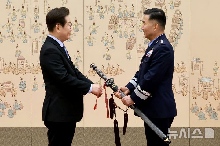 [서울=뉴시스] 최동준 기자 = 이재명 대통령이 2일 서울 용산 대통령실 청사에서 열린 대장 진급·보직 신고 및 삼정검 수치 수여식에서 합동참모의장 후보자인 진영승 전략사령관의 삼정검에 수치를 달아주고 있다. (대통령실통신사진기자단) 2025.09.02. photocdj@newsis.com