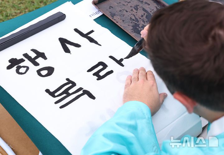 [서울=뉴시스] 최진석 기자 = 579돌 한글날인 9일 오전 서울 광화문광장에서 열린 광화문광장 휘호대회에 참가한 외국인이 한글을 쓰고 있다. 2025.10.09. myjs@newsis.com