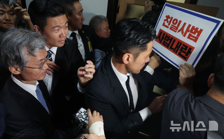 [서울=뉴시스] 고승민 기자 = 조희대 대법원장이 13일 서울 여의도 국회에서 열린 법제사법위원회의 대법원 등 국정감사에서 정회 후 이석하고 있다. 최혁진 무소속 의원이 항의 피켓을 들고 있다. 2025.10.13. kkssmm99@newsis.com