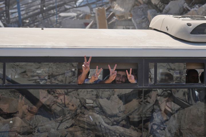 [칸유니스=AP/뉴시스] 이스라엘에서 풀려난 팔레스타인 수감자들이 13일(현지 시간) 가자지구 남부 칸유니스의 파괴된 거리를 지나며 환영 주민들을 향해 승리의 '브이'(V)를 그리고 있다. 이스라엘과 하마스의 휴전 합의 1단계에 따라 이스라엘에 수감 중이던 팔레스타인 수감자 1968명이 모두 풀려났다. 2025.10.14.