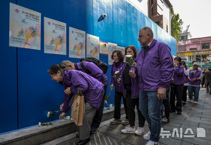 [서울=뉴시스] 정병혁 기자 = 10.29이태원참사 외국인 희생자 유가족들이 25일 서울 용산구 이태원역 1번 출구 앞 10·29 기억과 안전의 길을 찾아 참사 현장을 살펴보며 헌화를 하고 있다. 2025.10.25 jhope@newsis.com