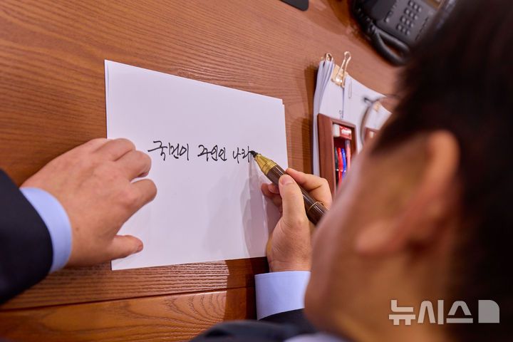 [서울=뉴시스] 최동준 기자 = 대통령실은 이재명 대통령이 11일 서울 용산 대통령실 청사에서 취임 기념 손목시계의 뒷판에 들어갈 문구를 쓰는 모습을 SNS에 공개했다. (사진=이재명 대통령 SNS) 2025.11.11. photo@newsis.com *재판매 및 DB 금지