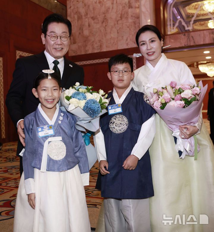 [아부다비=뉴시스] 최동준 기자 = 남아공 G20 정상회의 참석 차 아랍에미리트(UAE)를 국빈 방문한 이재명 대통령과 김혜경 여사가 17일(현지 시간) 아부다비의 한 호텔에서 열린 동포 만찬 간담회에서 화동에게 꽃다발을 받은 뒤 함께 기념촬영을 하고 있다. 2025.11.18. photocdj@newsis.com