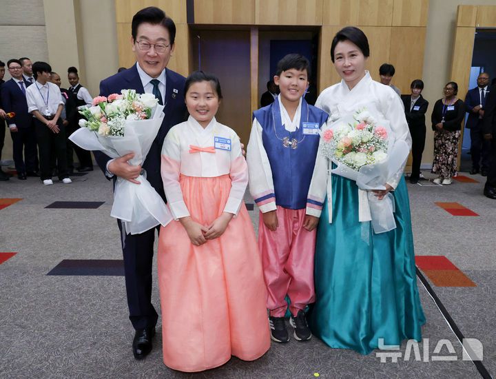 [요하네스버그=뉴시스] 최동준 기자 = 이재명 대통령과 김혜경 여사가 23일(현지 시간) 남아프리카공화국 요하네스버그 한 호텔에서 열린 동포 오찬 간담회에서 화동들에게 꽃다발을 받고 기념촬영을 하고 있다. 2025.11.23. photocdj@newsis.com