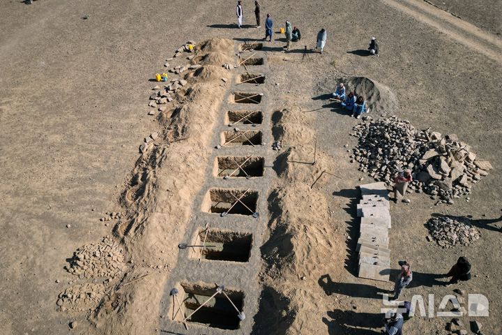 [AP/뉴시스] 야간 폭격으로 사망한 아동 9명과 여성 1명을 묻을 묘가 마련되고 있다