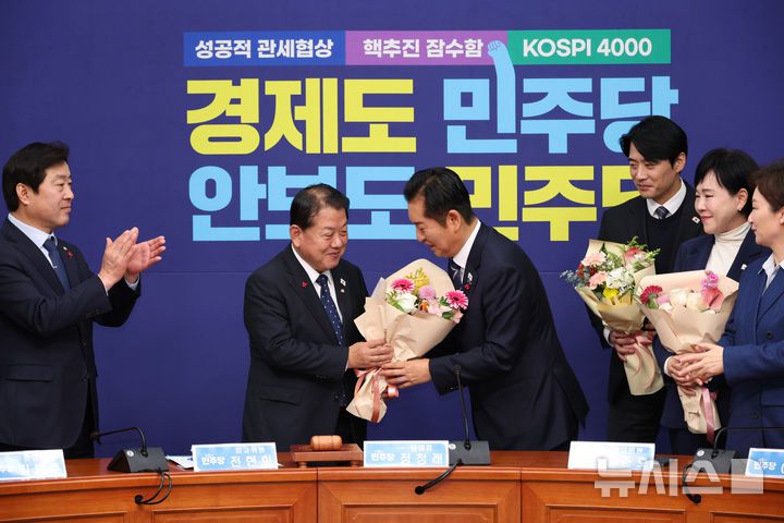 [서울=뉴시스] 김금보 기자 = 김병주 더불어민주당 의원이 1일 서울 여의도 국회에서 열린 최고위원회의에서 정청래 대표로 부터 최고위원 사퇴 기념 꽃다발을 받고 있다. 2025.12.01. kgb@newsis.com